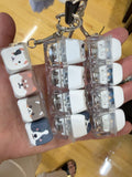 Animal-face clicker keychains held in a hand; sold individually