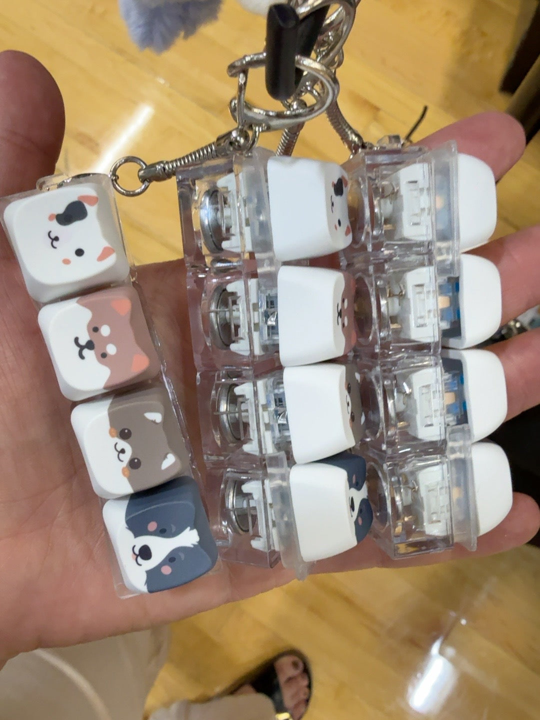 Animal-face clicker keychains held in a hand; sold individually