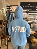 Back of the light-blue NeuroNest LOVED. hoodie with a heart-shaped O