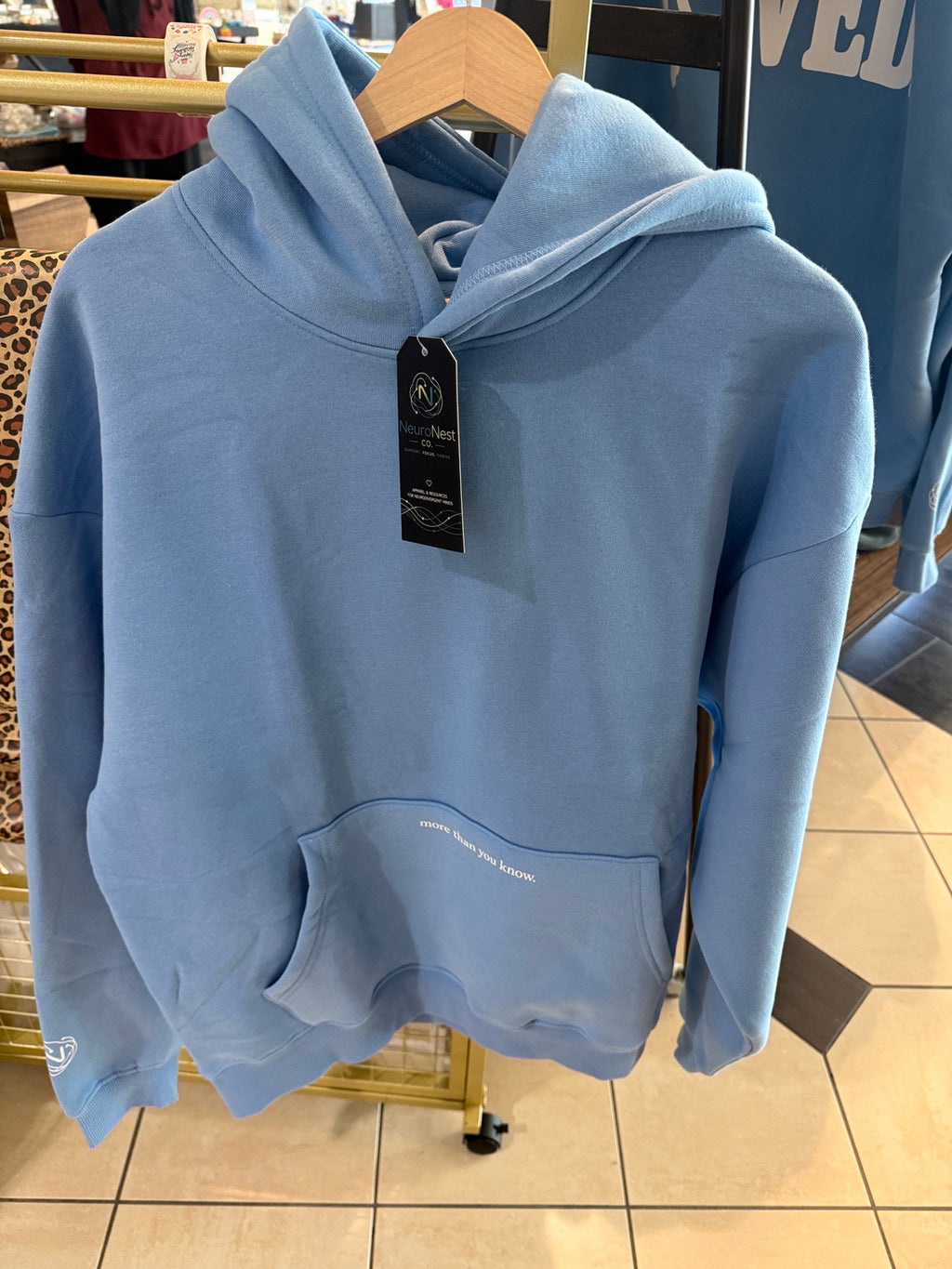 Front of the light-blue NeuroNest hoodie with more than you know. on the kangaroo pocket