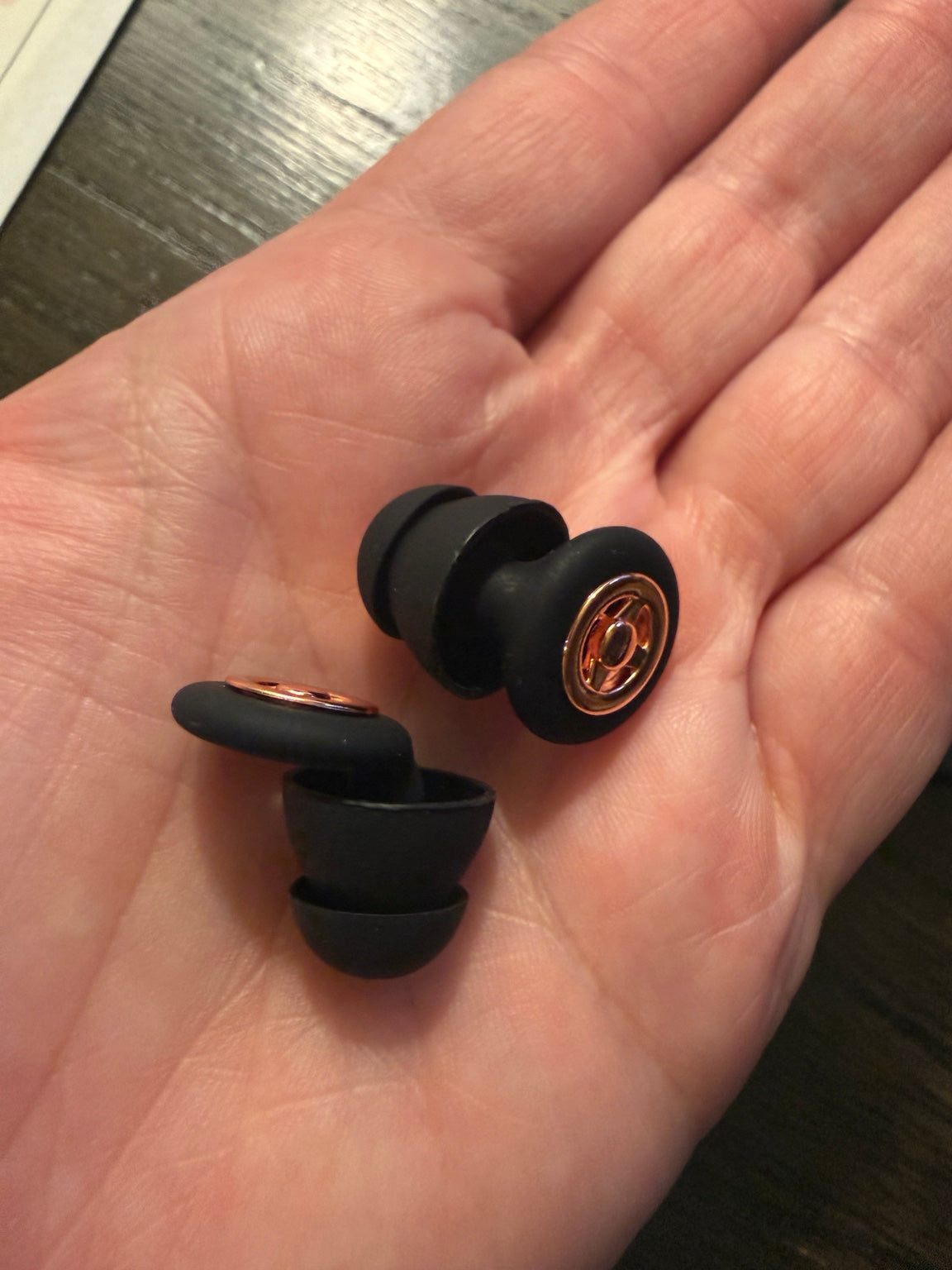 Black RESET sound filtering earbuds with metallic rose gold colored accents