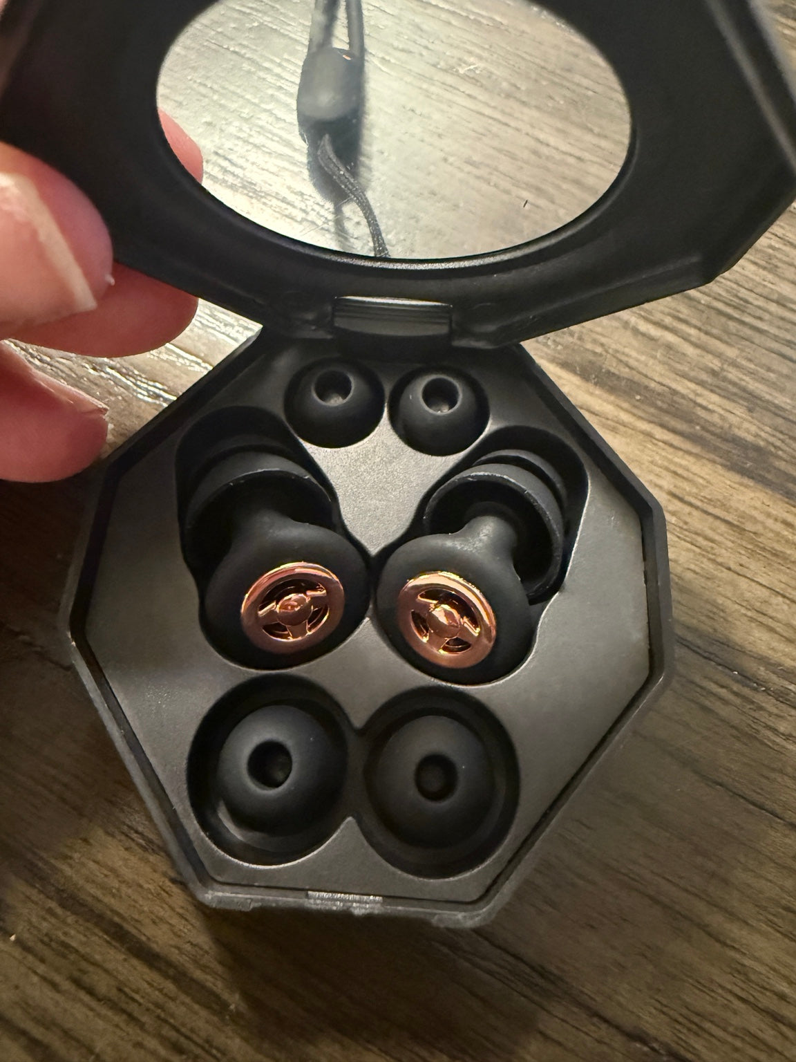 RESET sound filtering earbuds in an open black carrying case with spare ear tips